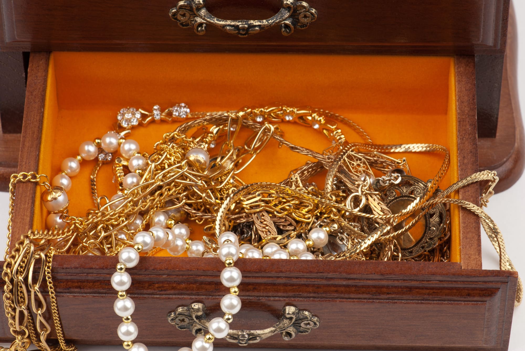 Tiroir à bijoux ouvert contenant des colliers en or, perles et chaîne entrelacées, illustrant le rachat d'or et de bijoux anciens à Montréal