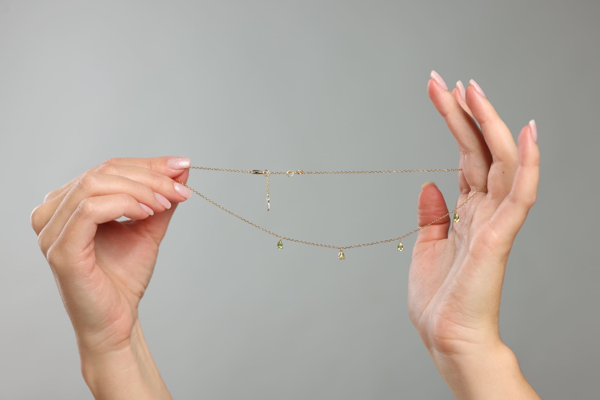 Collier fin en or tenu entre les mains pour examiner un bijou et vérifier s’il est en or véritable.