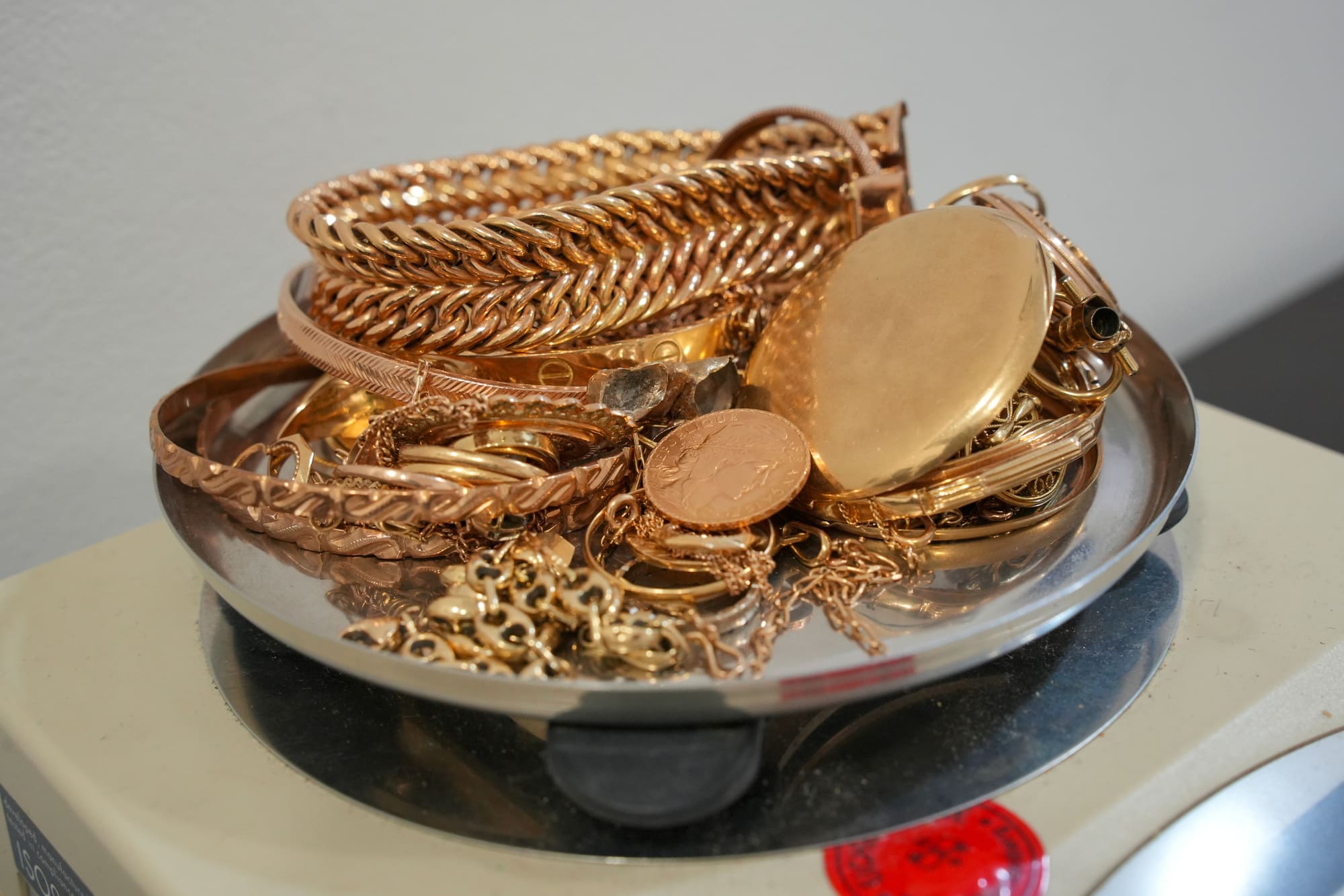 Bijoux en or pesés sur une balance pour déterminer leur valeur lors d’un rachat d’or.