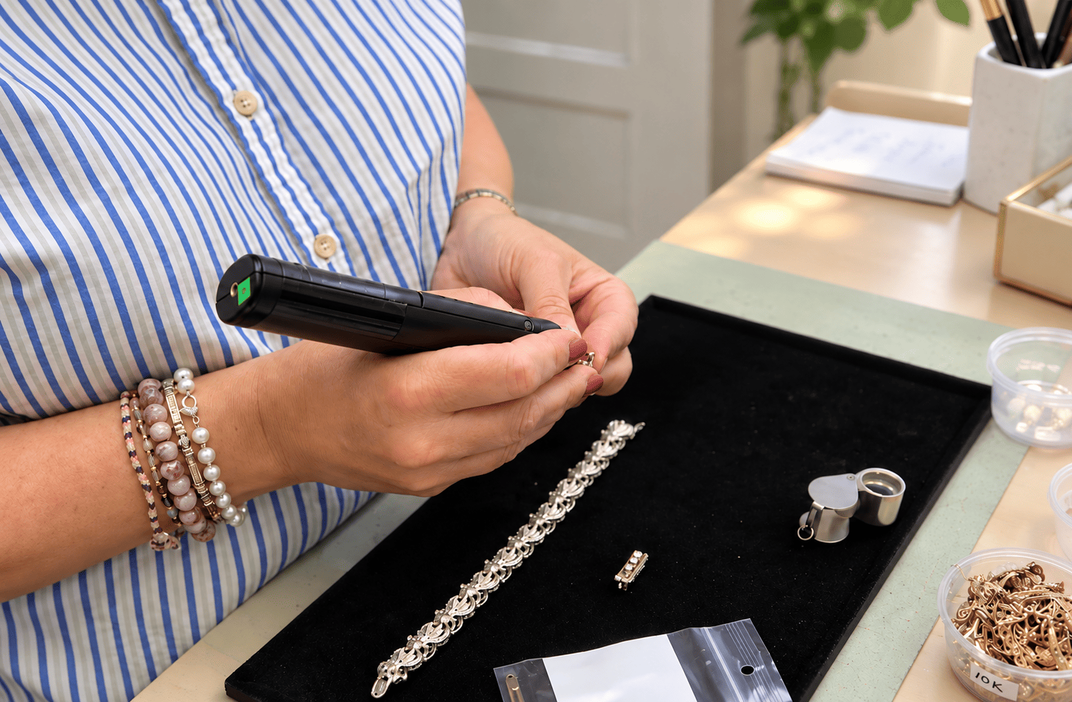 Bijoutière utilisant un testeur de diamant pour vérifier un bijou en bijouterie.